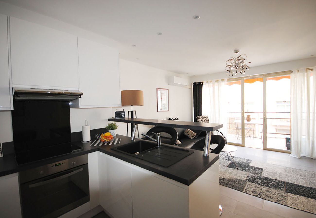 Fully equipped kitchen with a view of the bright living room
