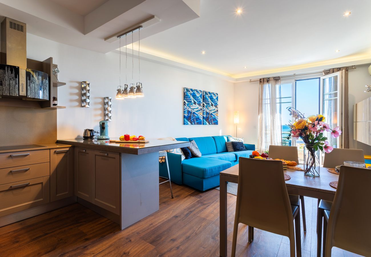 Bright living room with kitchen, blue sofa, and dining table.