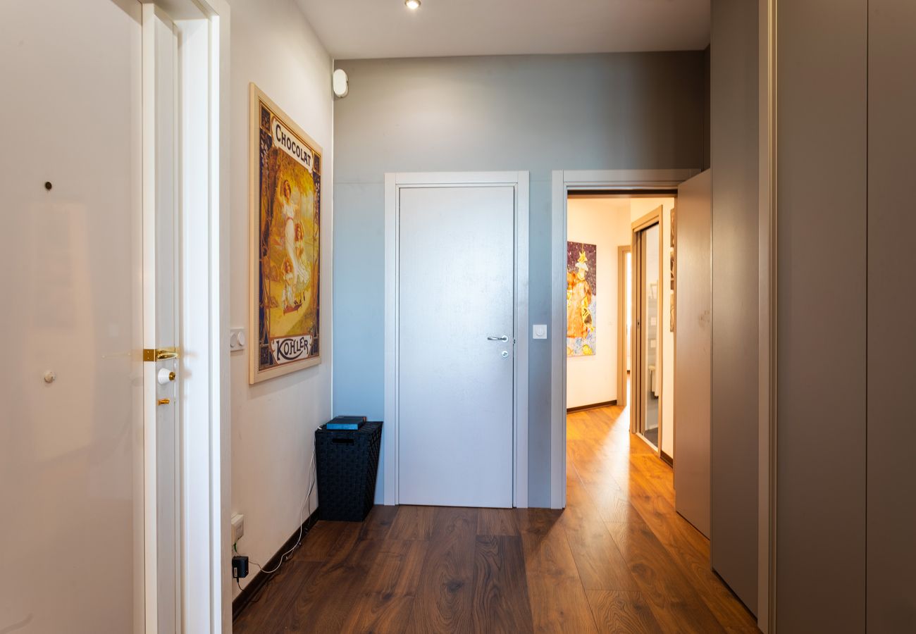 Elegant entrance with wooden flooring, artistic decor, and built-in storage.