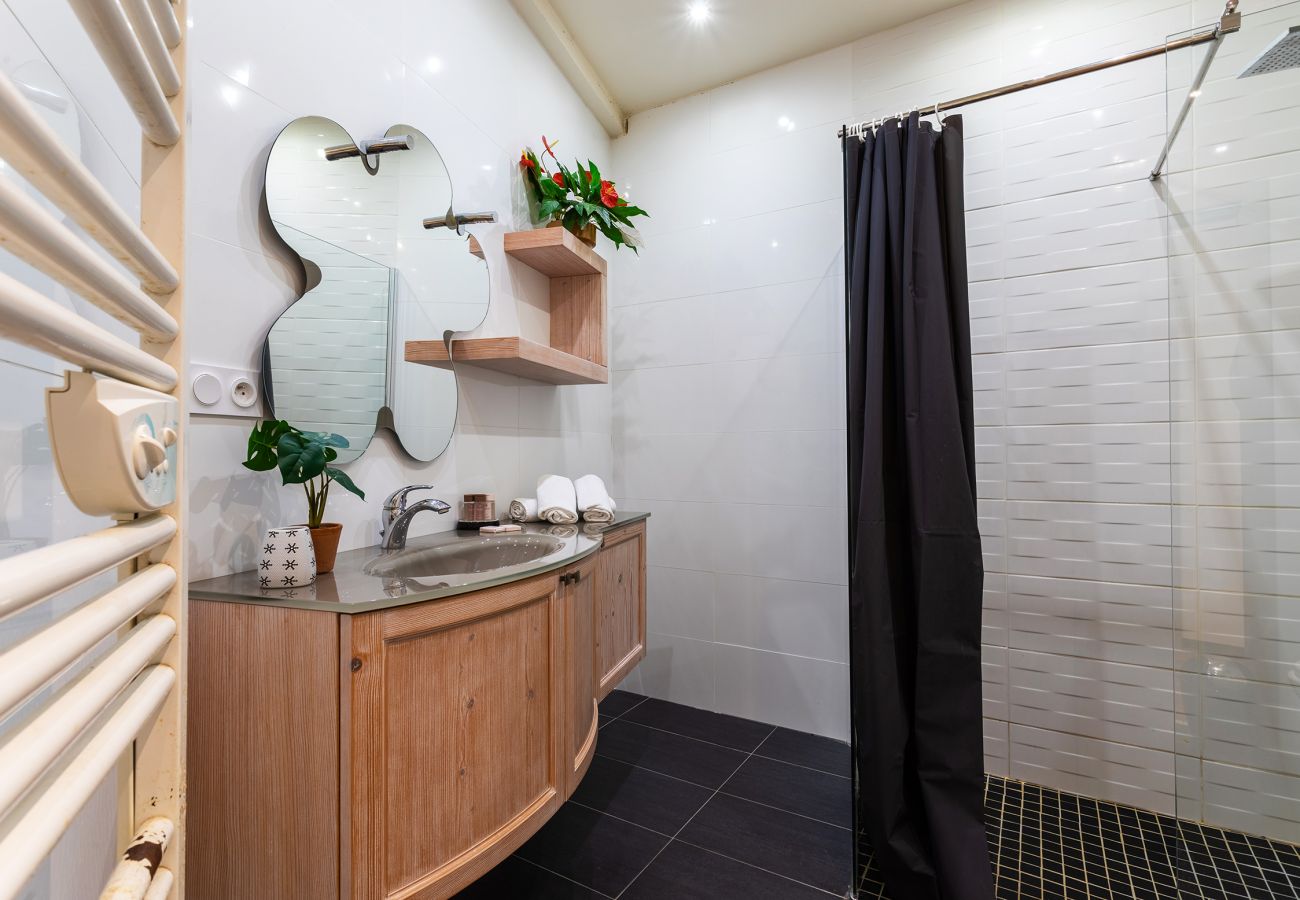 Salle de bain spacieuse avec douche italienne, design raffiné et confort absolu.